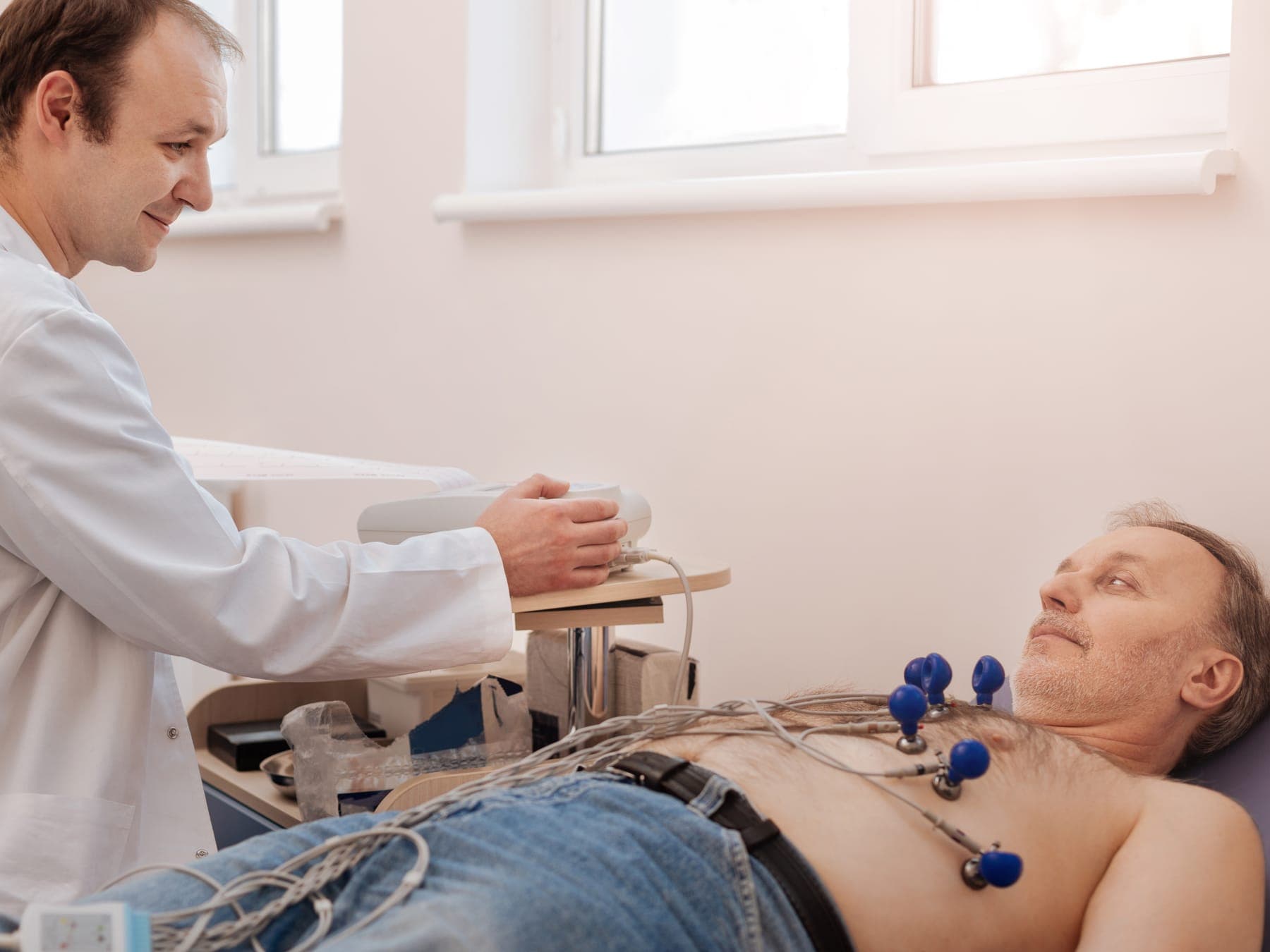 Médico conversando con un paciente durante un electrocardiograma